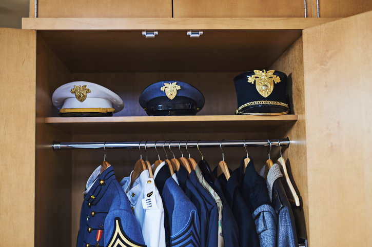 wojskowe mundury i czapki w szafie